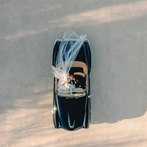 Aerial shot of bride and groom in a classic car